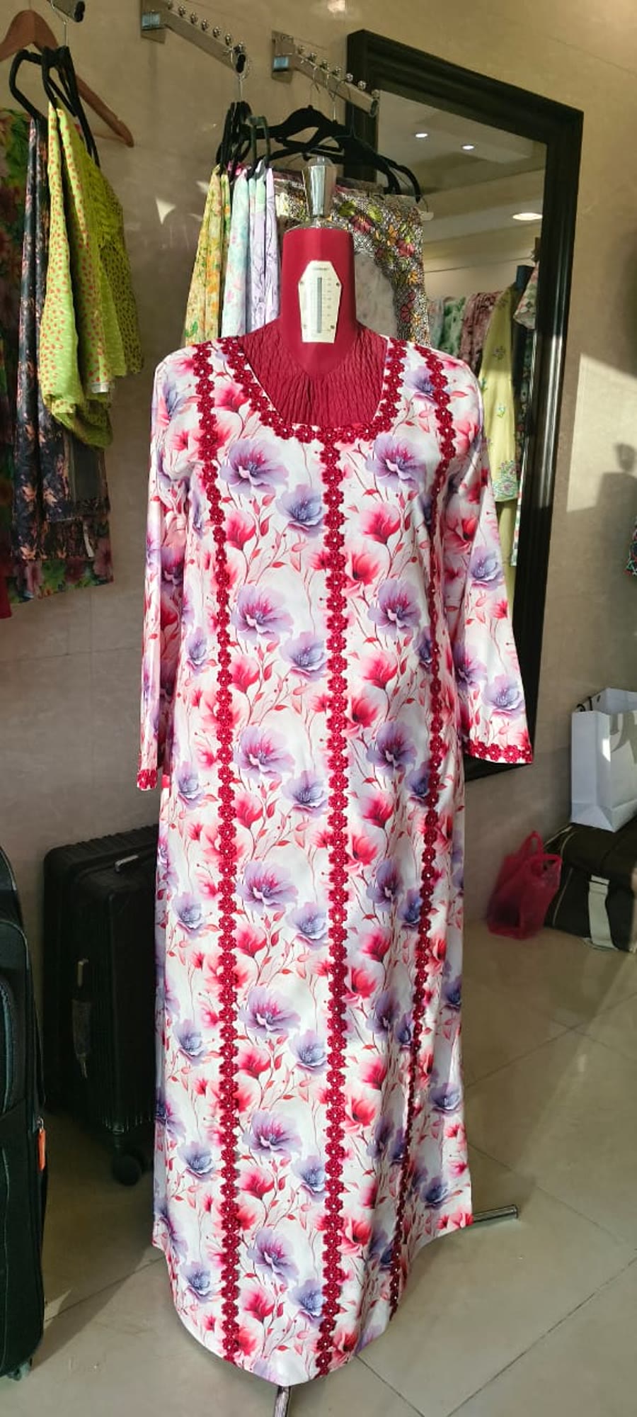 Floral printed abaya with beaded trim, on display in the shop